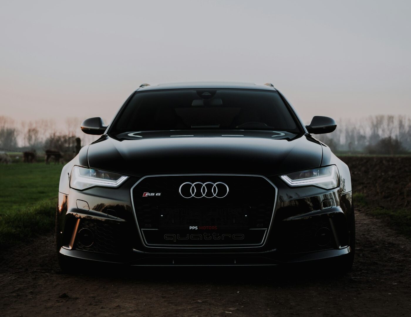 Zwarte Audi RS6 Avant frontaal bij zonsondergang